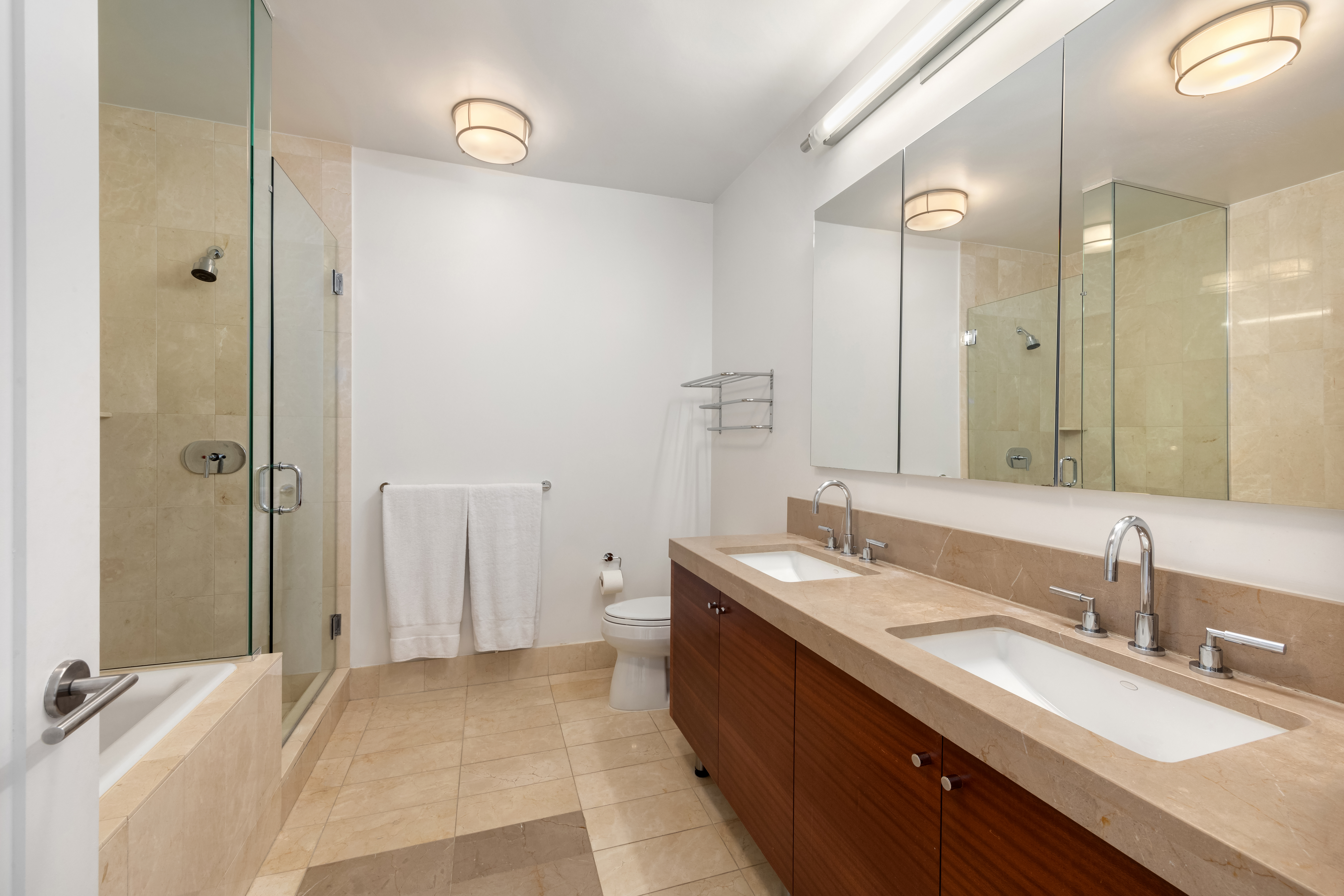 30 West Street, Unit 23F Manhattan, NY 10004 - Photo 8 of 12 a spacious bathroom with a granite countertop sink mirror and double