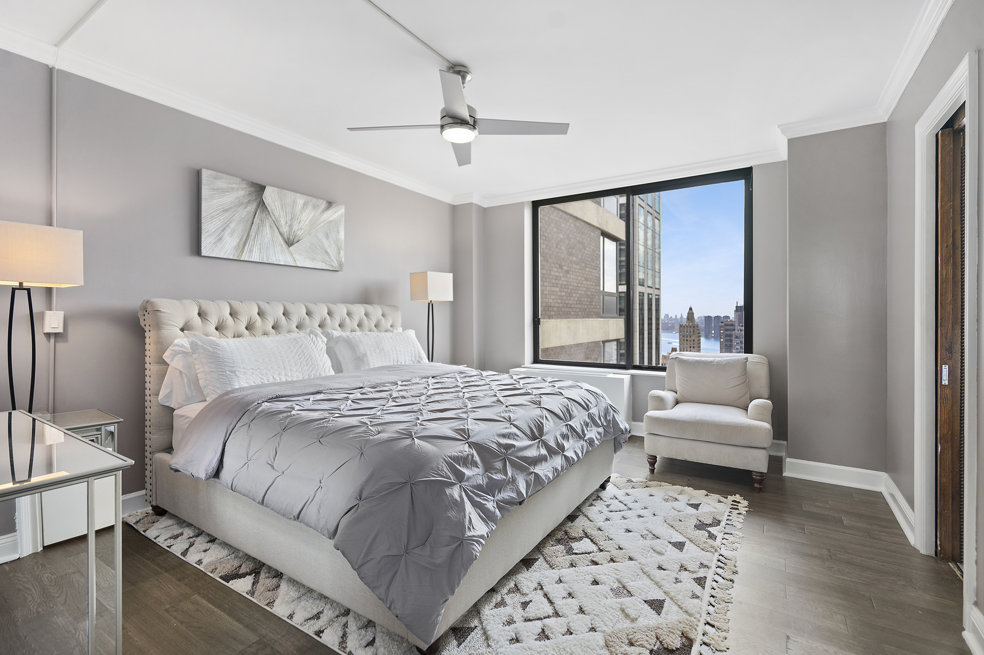 418 East 59th Street, Unit 35A Manhattan, NY 10022 - Photo 4 of 7 a bedroom with a large bed and a couch