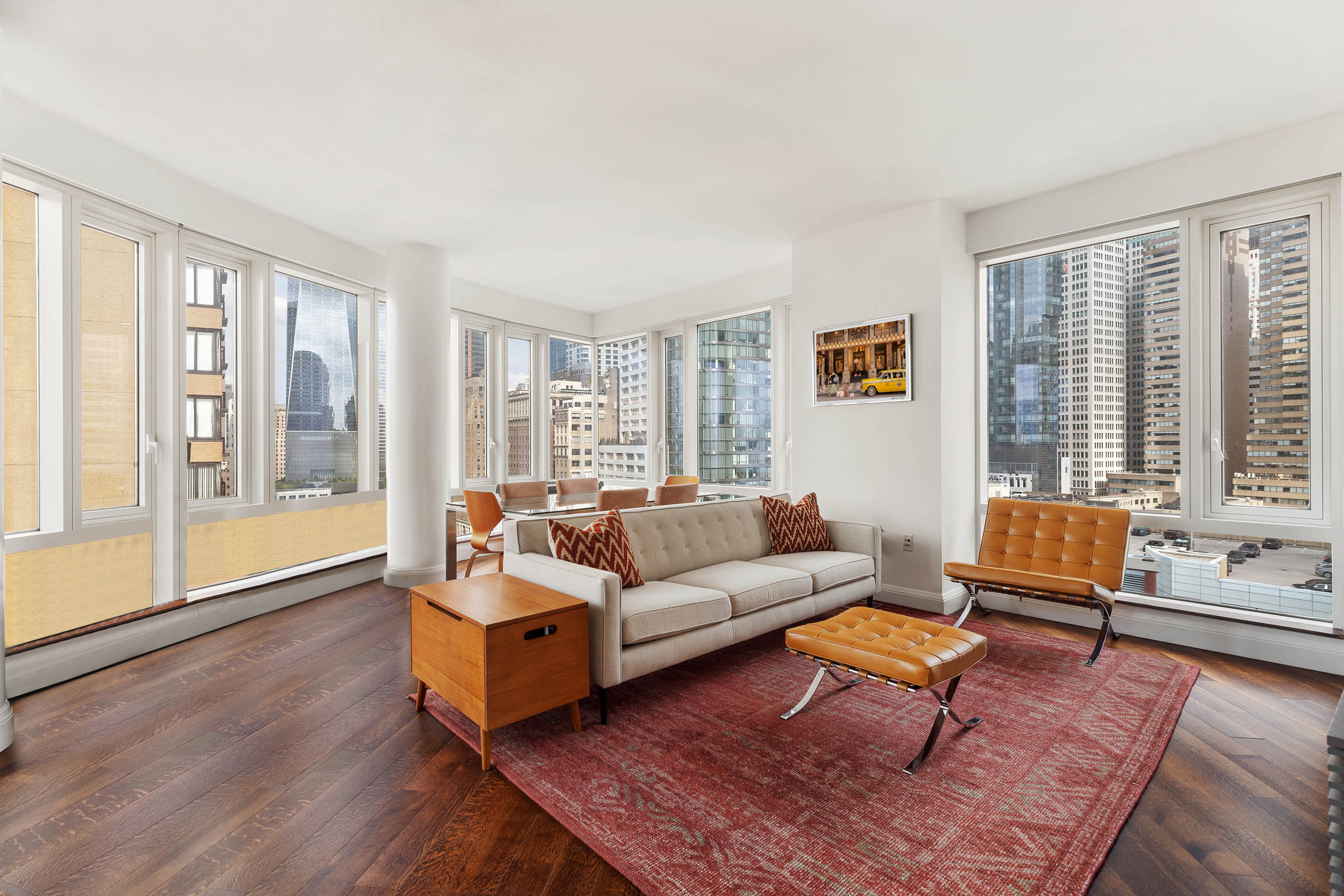 70 Little West Street, Unit 14B Manhattan, NY 10004 - Photo 3 of 17 a living room with furniture and a large window with wooden floor