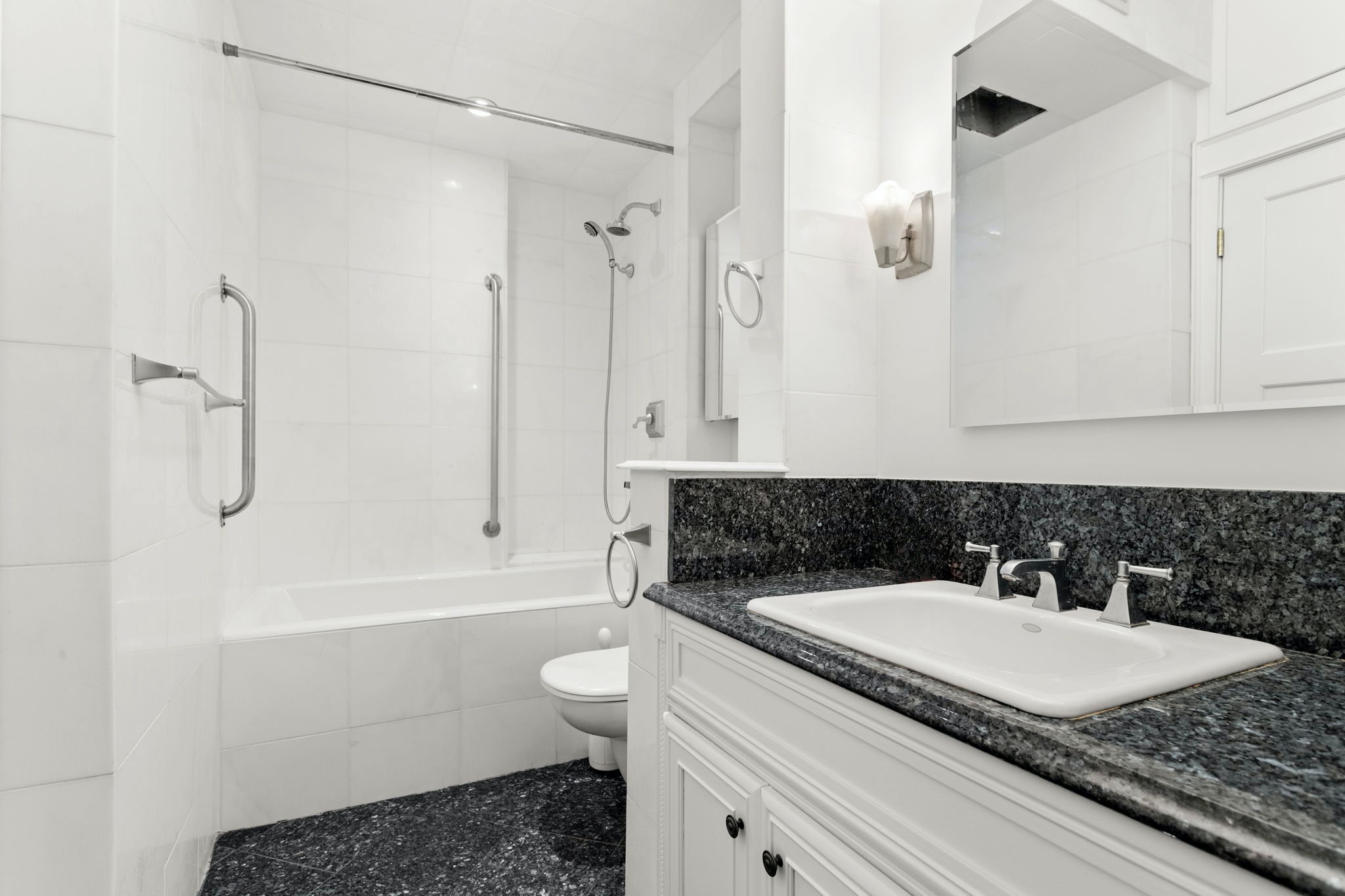 60 East 8th Street, Unit 24J Manhattan, NY 10003 - Photo 9 of 16 a bathroom with a granite countertop sink a toilet and shower