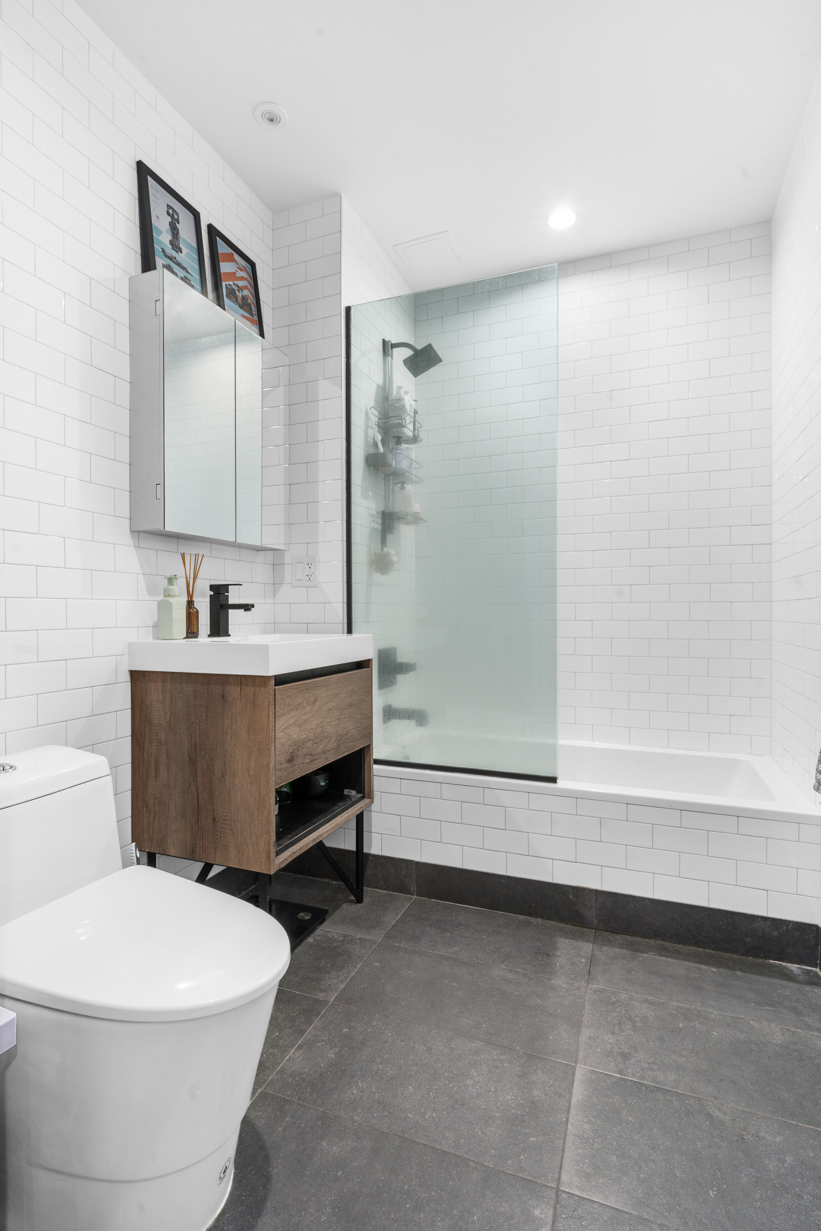 1229 Putnam Avenue, Unit 2A Brooklyn, NY 11221 - Photo 5 of 10 a bathroom with a sink a toilet and vanity
