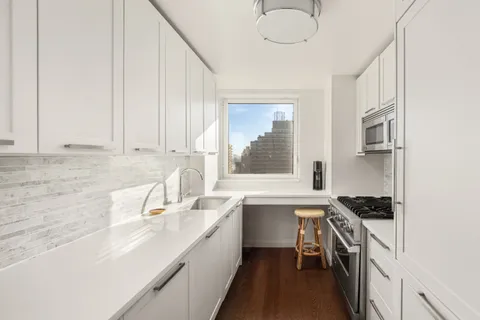 a kitchen that has a sink and a stove in it