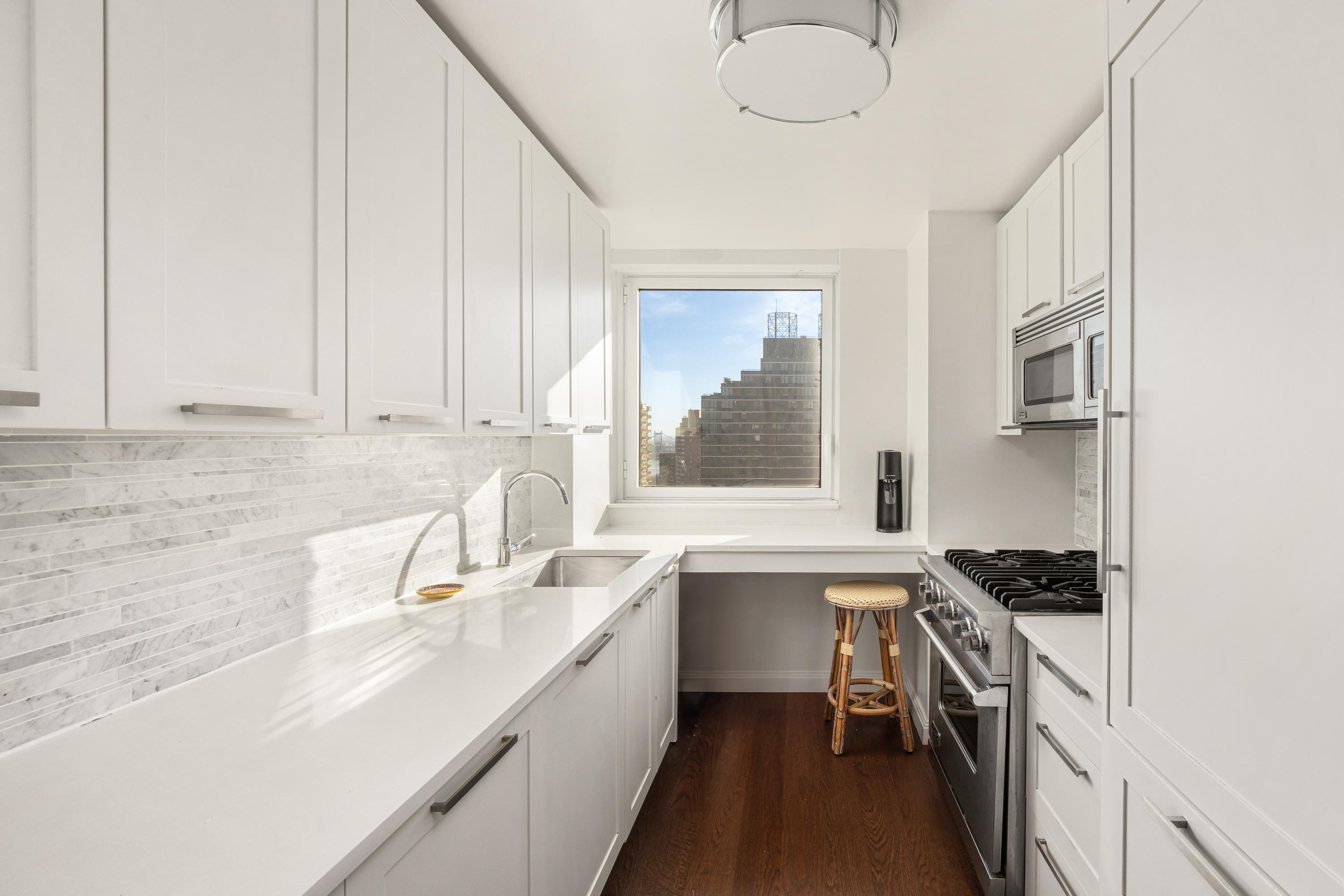 200 East 94th Street, Unit 2309 Manhattan, NY 10128 - Photo 5 of 17 a kitchen that has a sink and a stove in it
