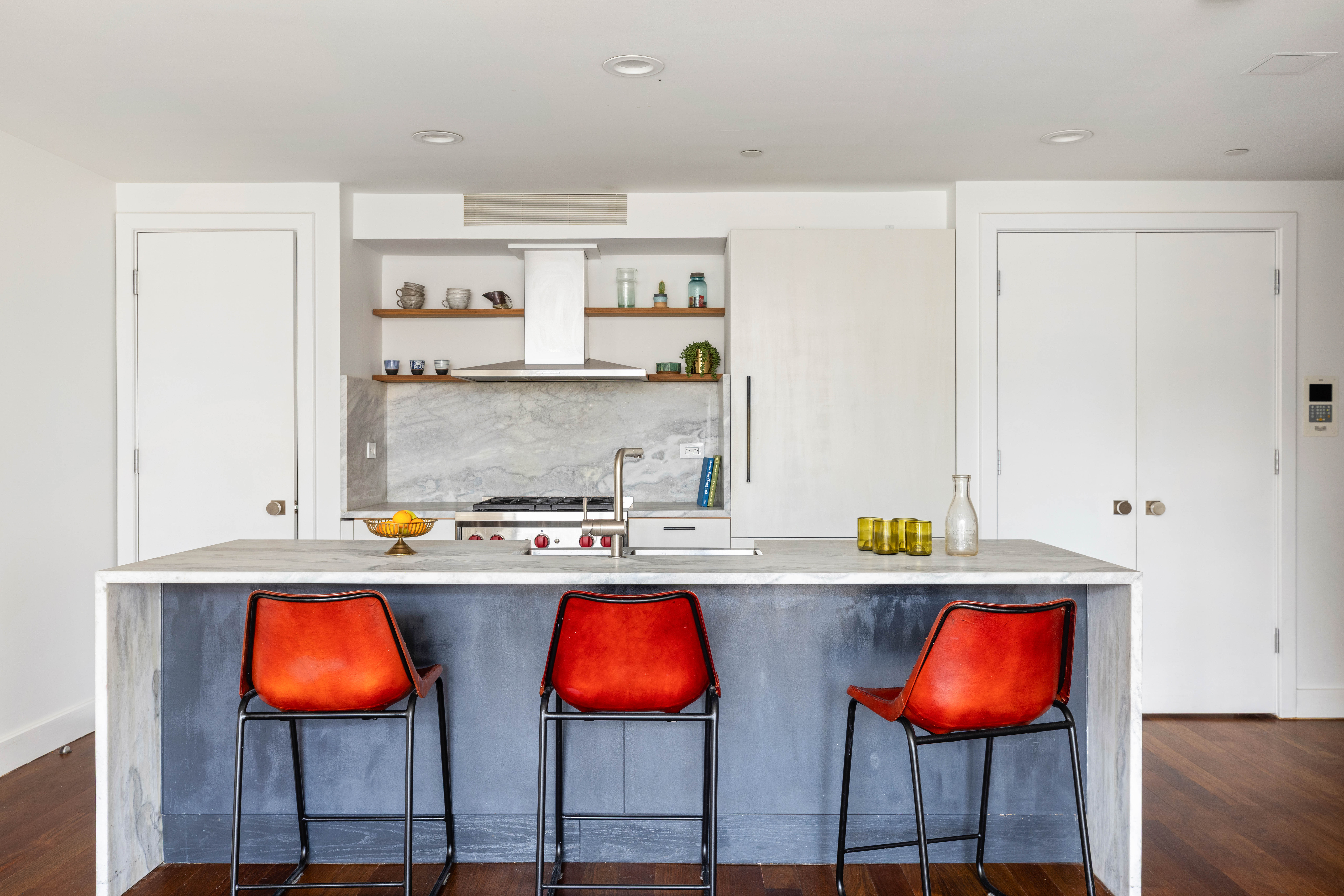 a kitchen with stainless steel appliances granite countertop sink stove and white cabinets with wooden floor