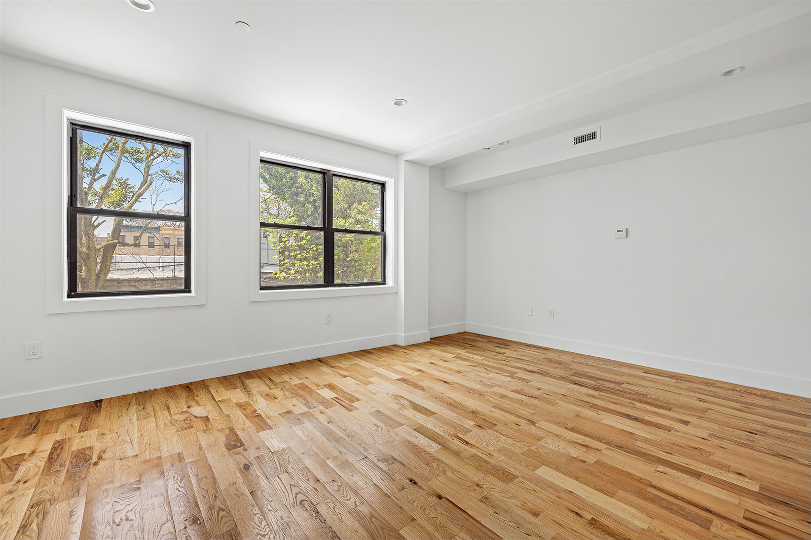 422 East 31st Street Brooklyn, NY 11226 - Photo 3 of 16 a view of an empty room with wooden floor and a window