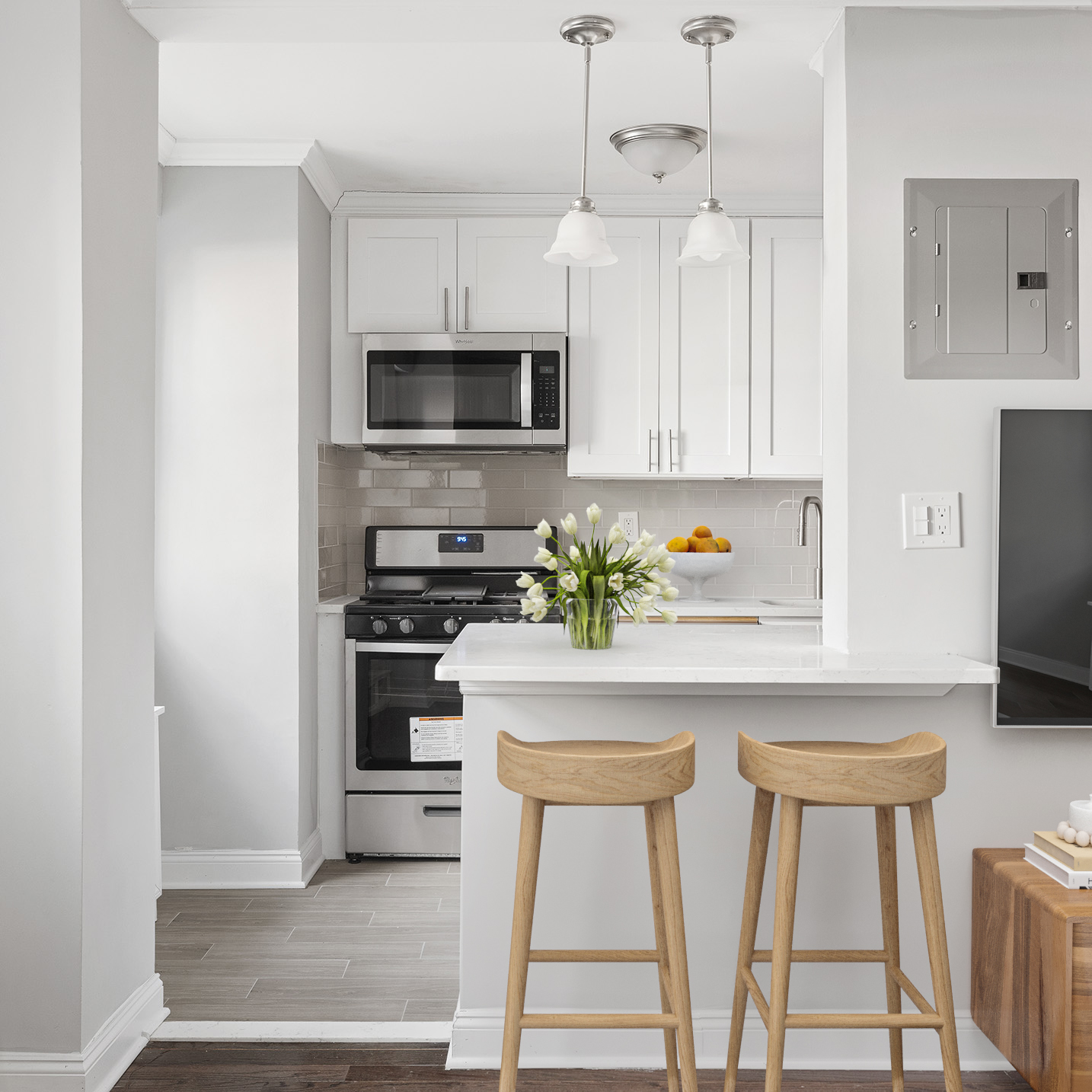 175 Willoughby Street, Unit 5K Brooklyn, NY 11201 - Photo 4 of 15 a kitchen with stainless steel appliances a stove a microwave and white cabinets
