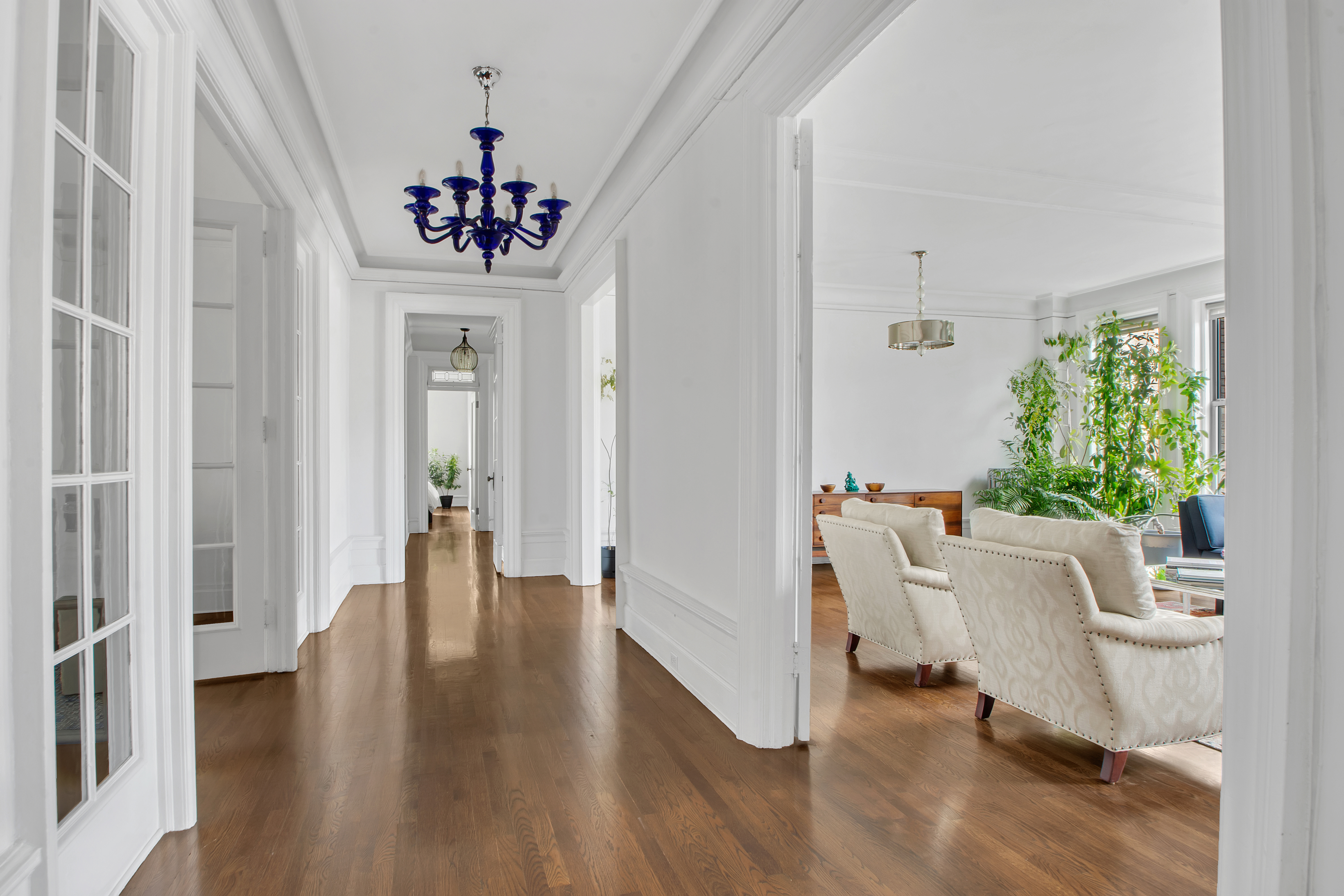 800 Riverside Drive, Unit 2E Manhattan, NY 10032 - Photo 9 of 27 a living room with furniture and a chandelier