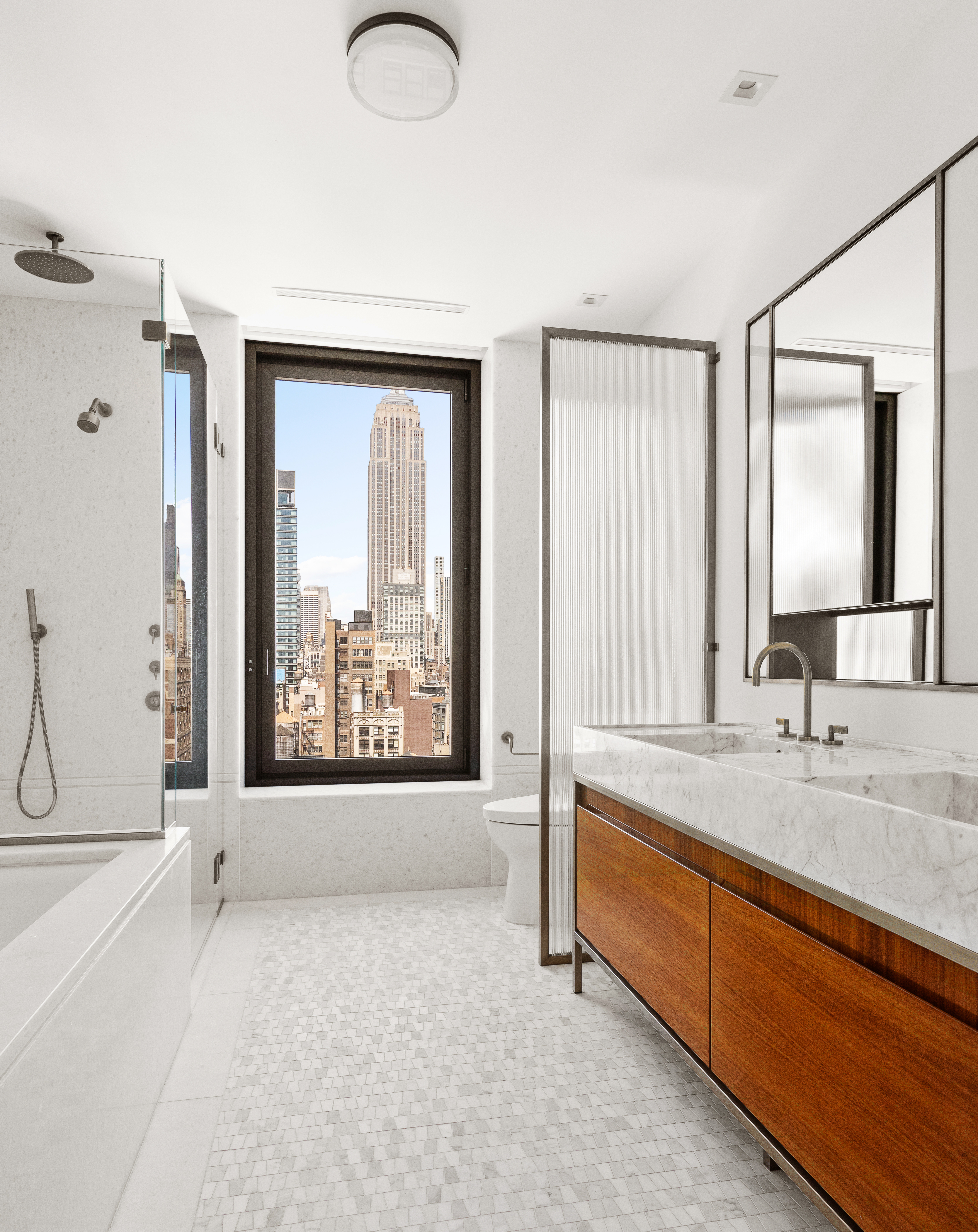 39 West 23rd Street, Unit 21A Manhattan, NY 10010 - Photo 8 of 14 a spacious bathroom with a tub sink and mirror