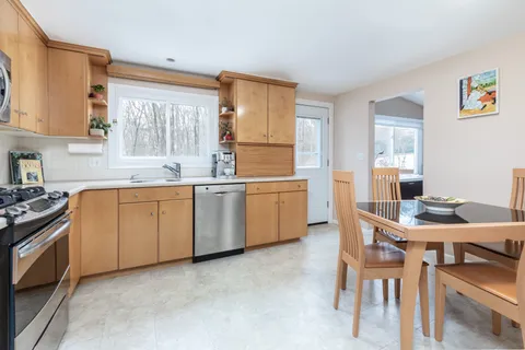 a kitchen with a stove a sink a dining table and chairs