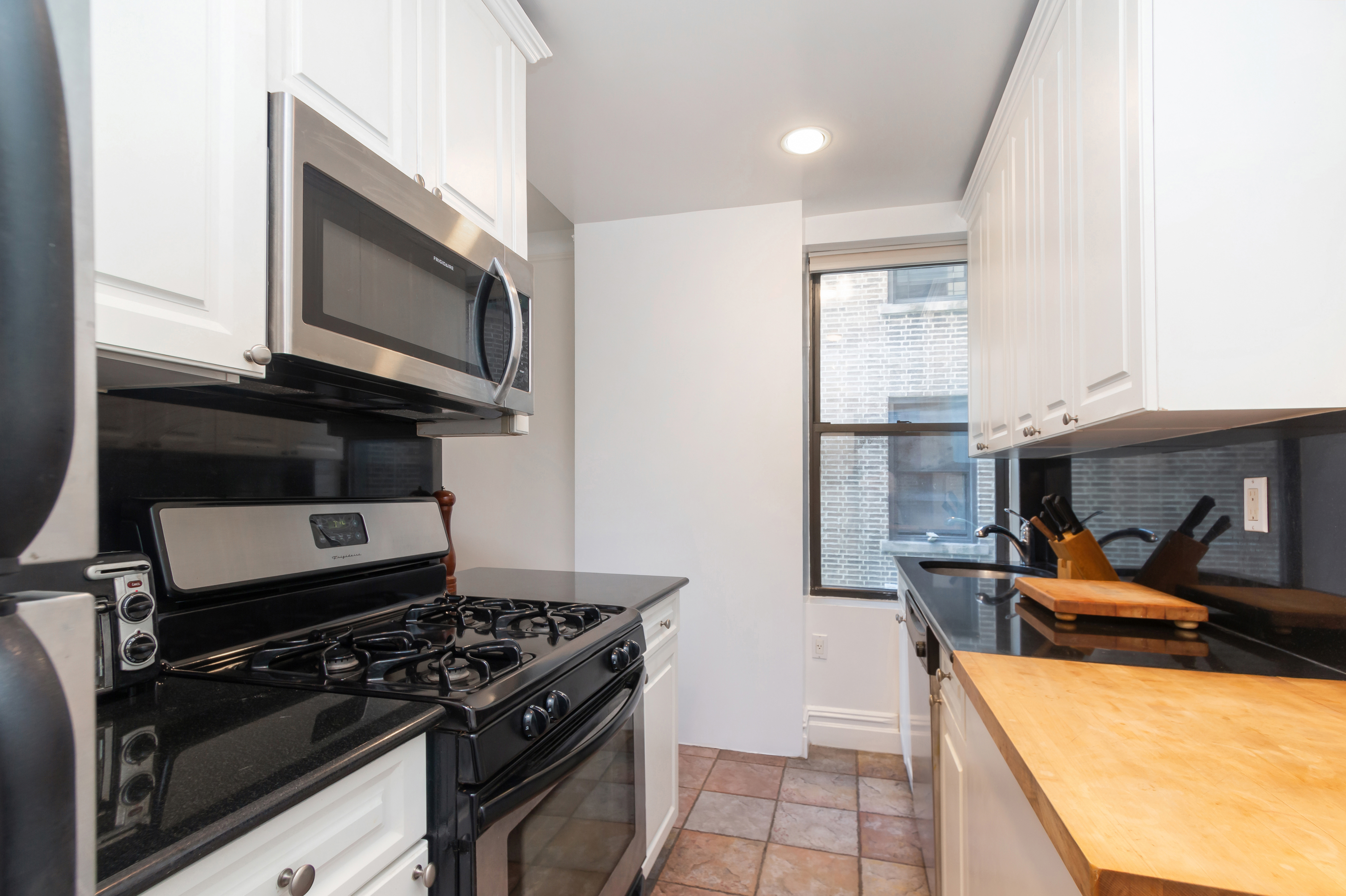 801 Riverside Drive, Unit 4F Manhattan, NY 10032 - Photo 8 of 13 a kitchen with stainless steel appliances granite countertop a stove and a microwave