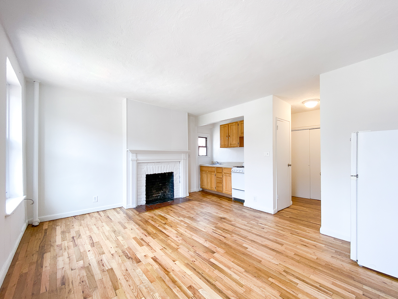 400 East 9th Street, Unit 3B Manhattan, NY 10009 - Photo 3 of 12 a view of empty room with wooden floor and fireplace