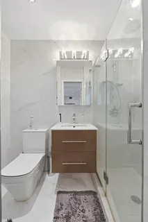a bathroom with a sink a toilet and shower