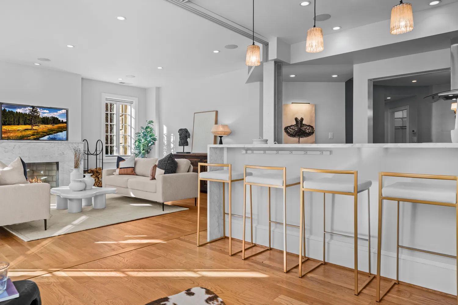 a living room with furniture a flat screen tv and kitchen view