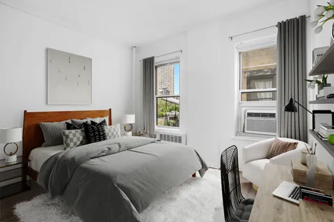 a bedroom with furniture a window and a flat screen tv