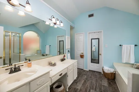 a spacious bathroom with a double vanity sink and a mirror