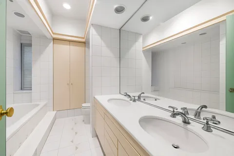 a bathroom with a tub sink and mirror