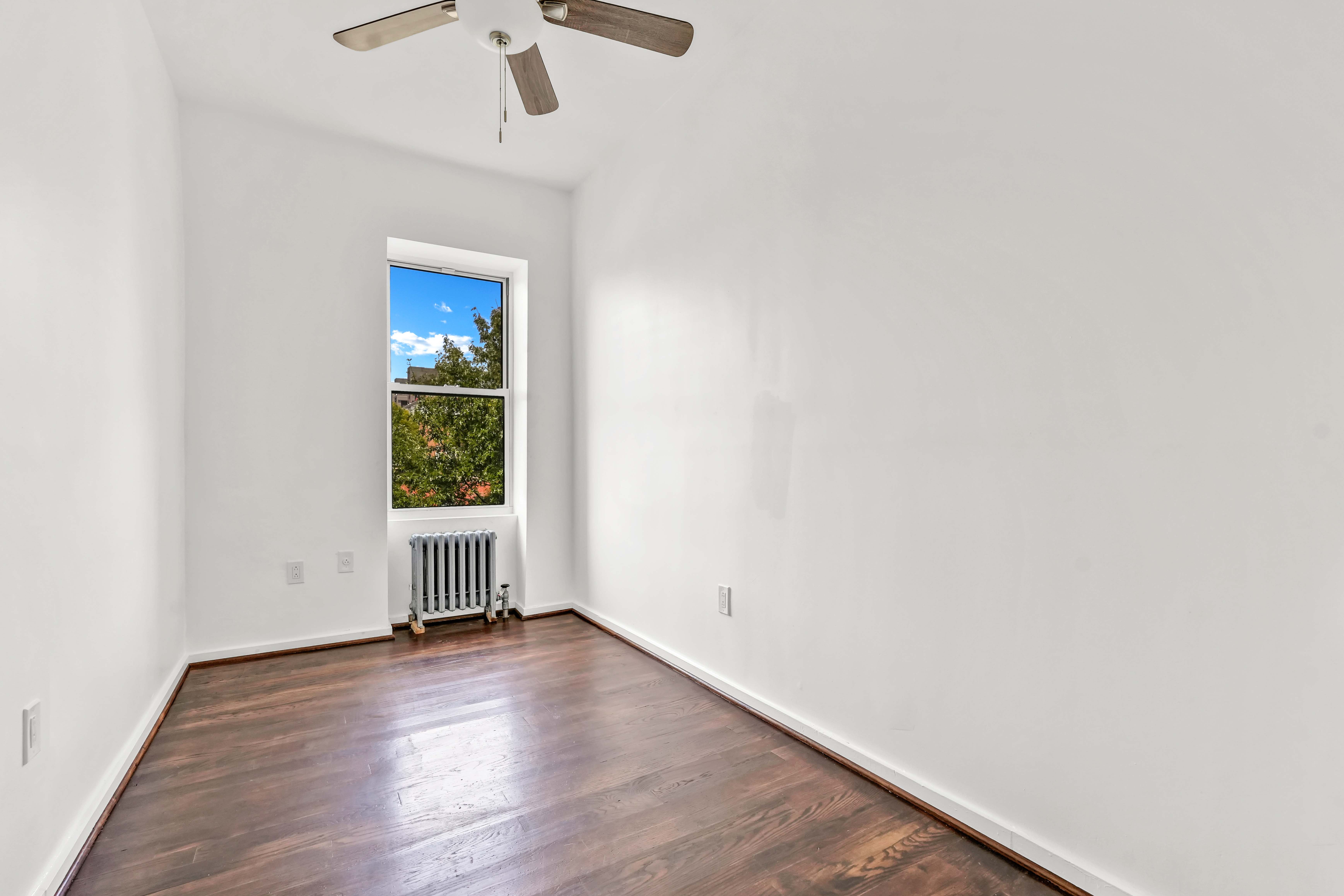 238 Vernon Avenue, Unit 3 Brooklyn, NY 11206 - Photo 14 of 19 a view of empty room with wooden floor and fan