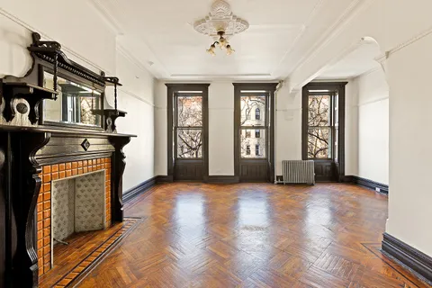 a view of a hallway with wooden floor windows and a fireplace