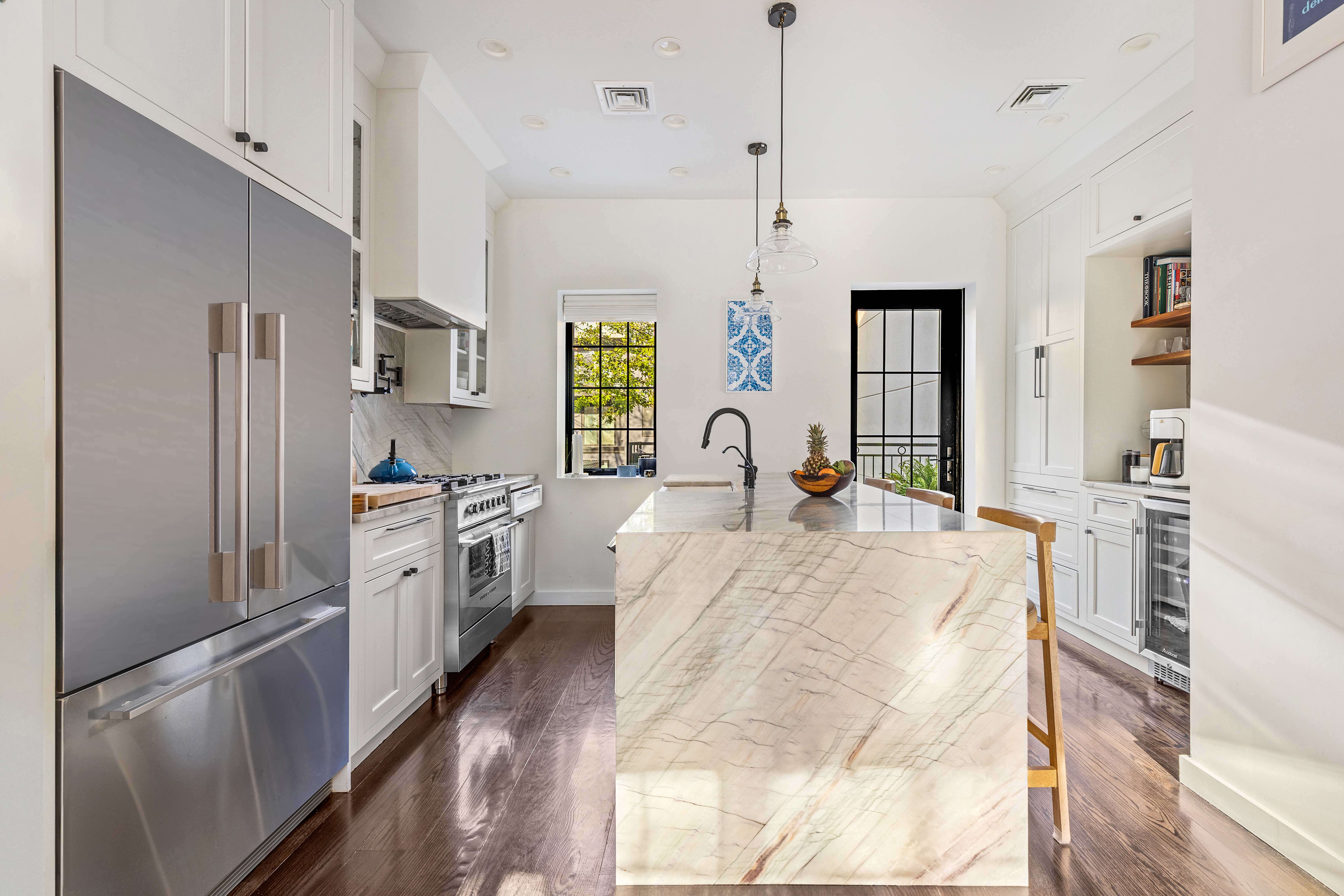 211 14th Street Brooklyn, NY 11215 - Photo 4 of 18 a large kitchen with kitchen island a large counter top space a sink stainless steel appliances and cabinets