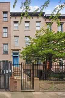 a front view of a house with a tree