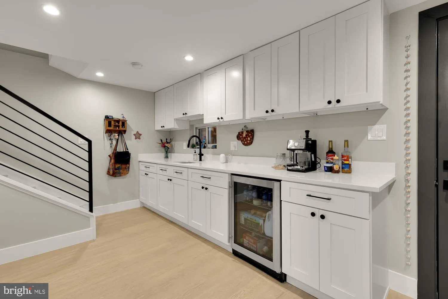 a kitchen with white cabinets and sink
