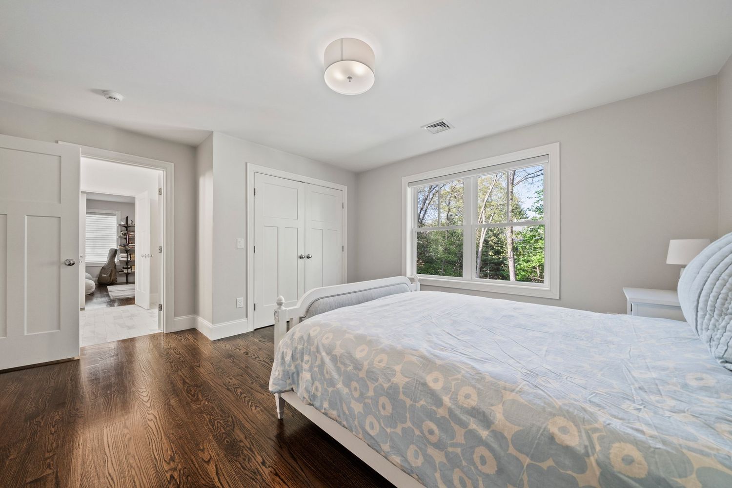 a spacious bedroom with a bed a book shelf and a book shelf