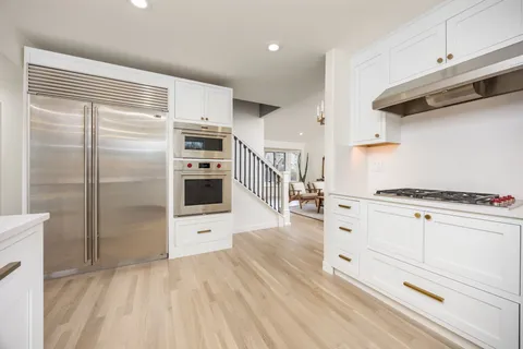 a kitchen with stainless steel appliances a refrigerator and a stove top oven