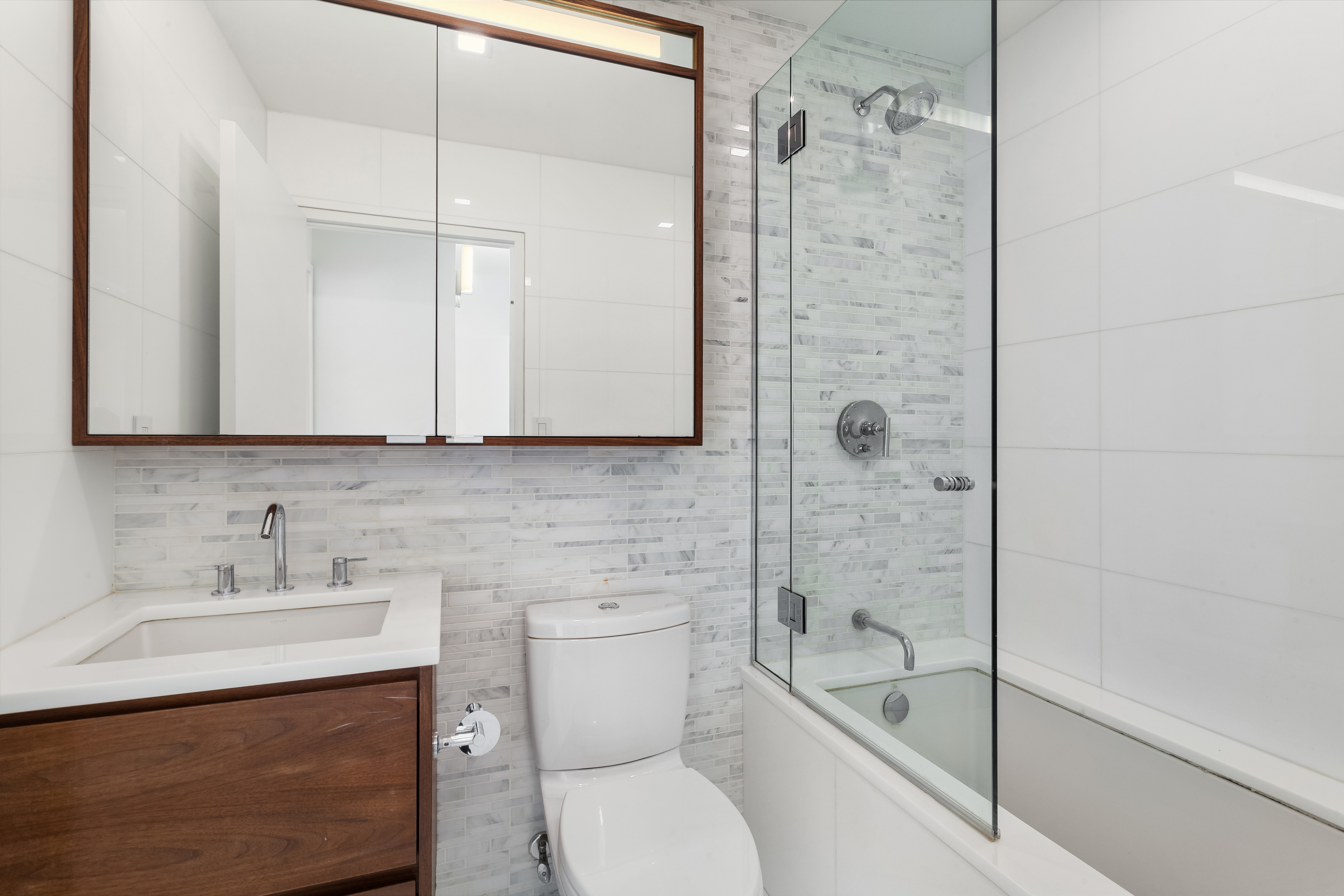 301 West 53rd Street, Unit 24H Manhattan, NY 10019 - Photo 4 of 15 a bathroom with a sink toilet and shower