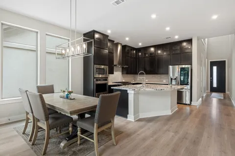 a kitchen with a table chairs refrigerator and cabinets
