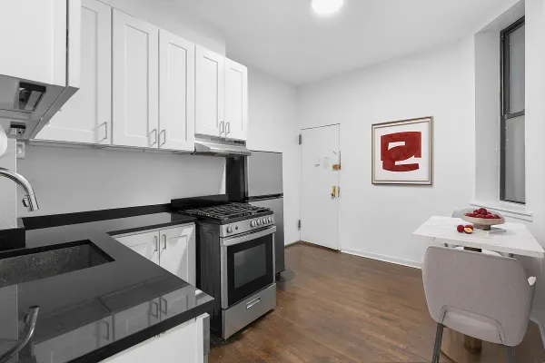 a kitchen with stainless steel appliances a stove a refrigerator white cabinets and wooden floor