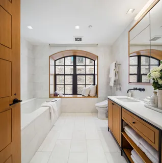 a spacious bathroom with a granite countertop sink a large mirror and a bathtub