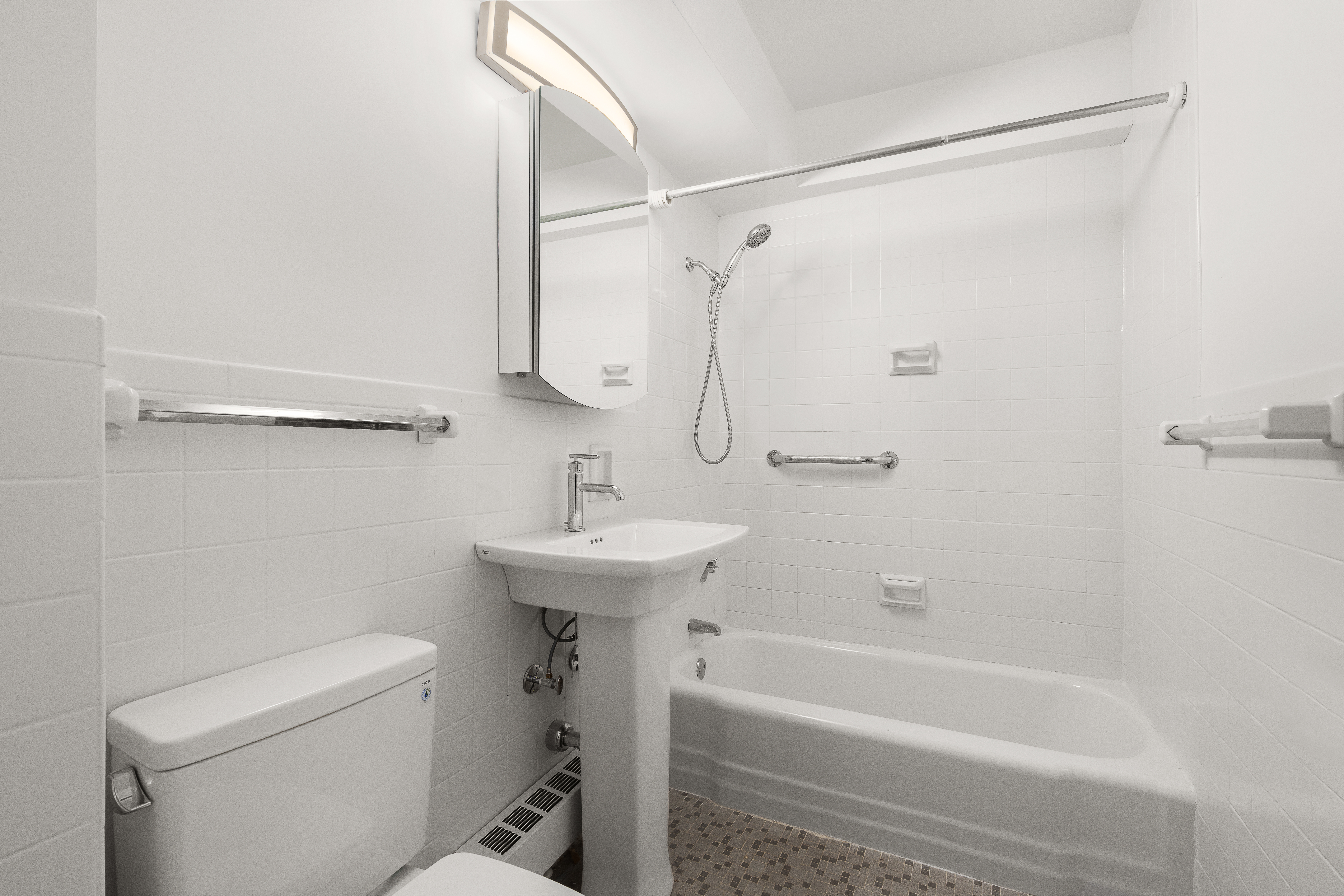 401 East 65th Street, Unit 11G Manhattan, NY 10065 - Photo 5 of 6 a bathroom with a sink a toilet and shower
