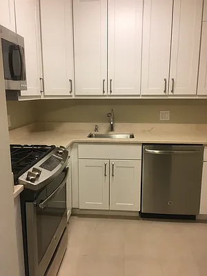 30 West 63rd Street, Unit 28L Manhattan, NY 10023 - Photo 11 of 11 a kitchen with a sink stove and microwave