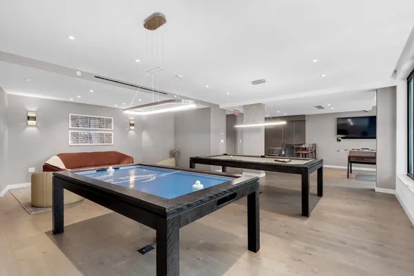 a room with furniture pool table wooden floor and windows