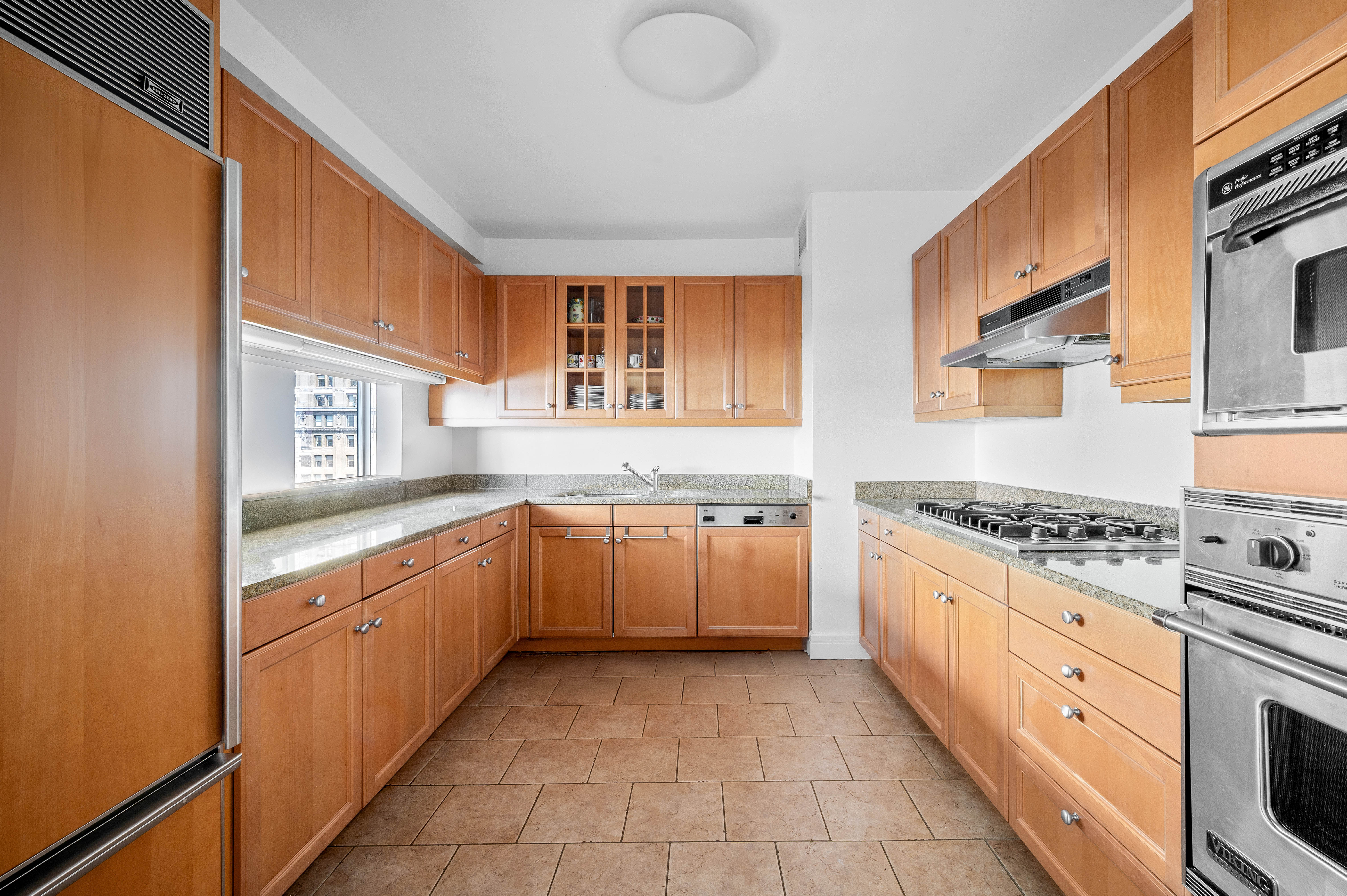 10 West Street, Unit 28C Manhattan, NY 10004 - Photo 5 of 12 a large kitchen with stainless steel appliances granite countertop a stove and a sink