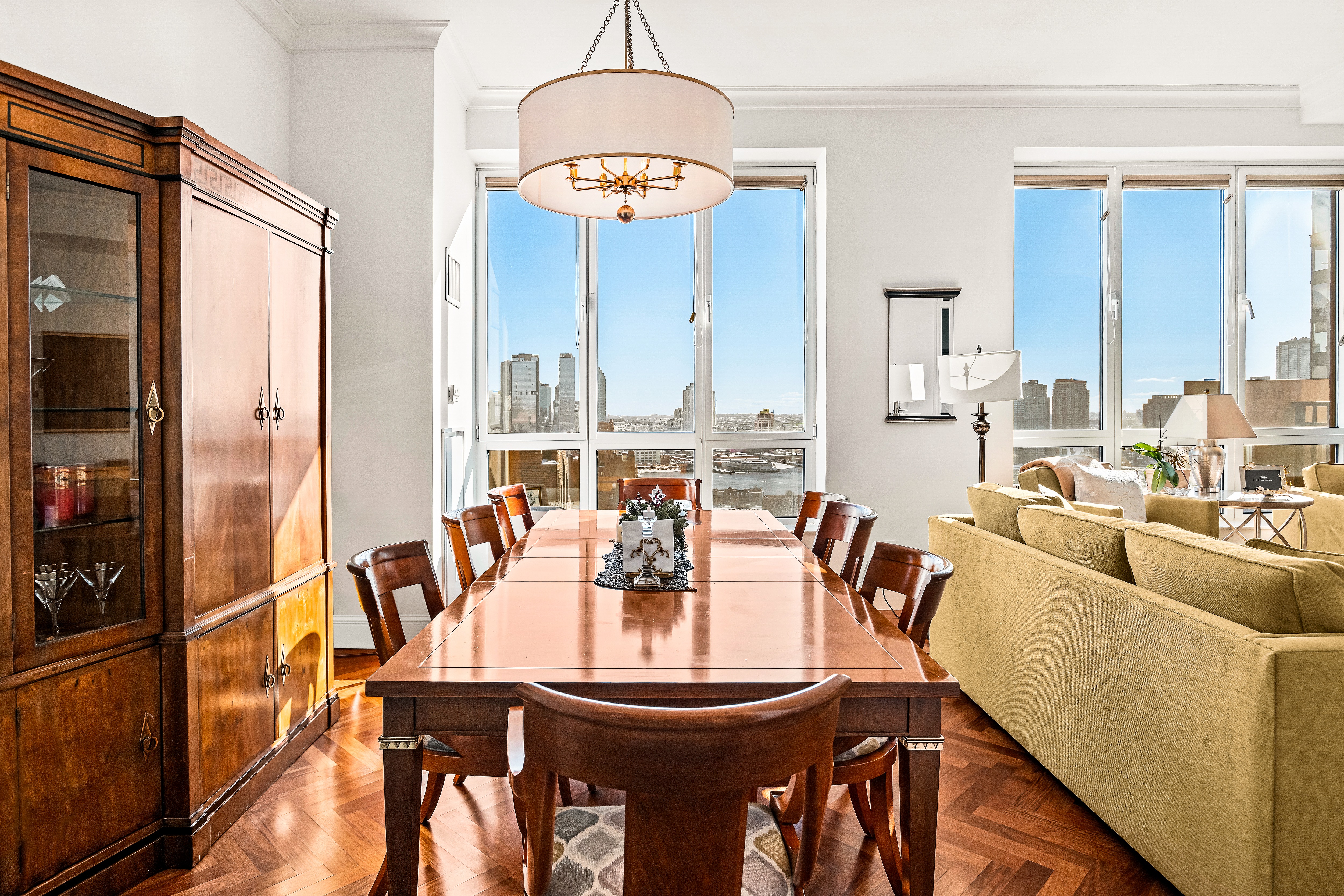 351 East 51st Street, Unit PH7A Manhattan, NY 10022 - Photo 2 of 14 a dining room with furniture a chandelier and a large mirror