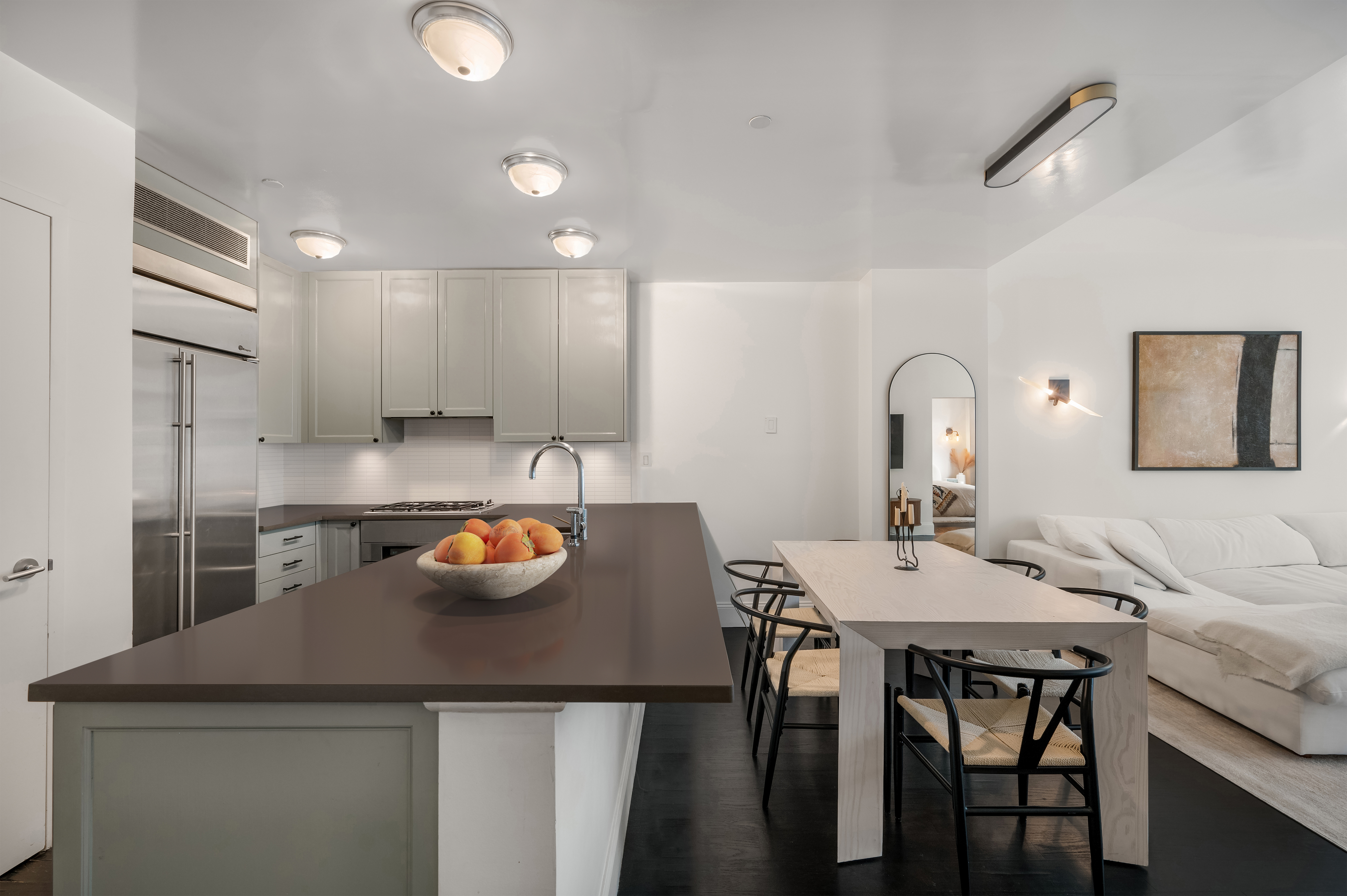 125 West 22nd Street, Unit 8B Manhattan, NY 10011 - Photo 2 of 10 a kitchen with a refrigerator a stove a sink and a dining table