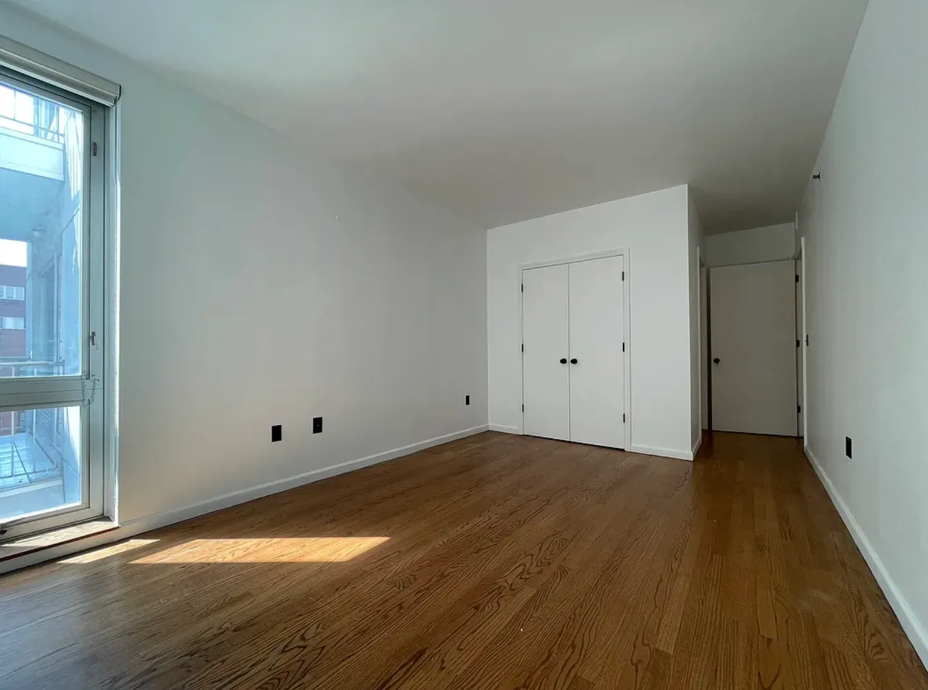 a view of empty room with wooden floor