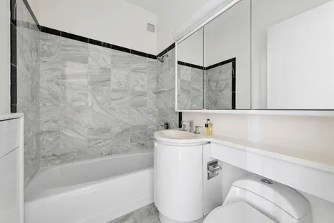 a bathroom with a bathtub a sink a toilet and a mirror