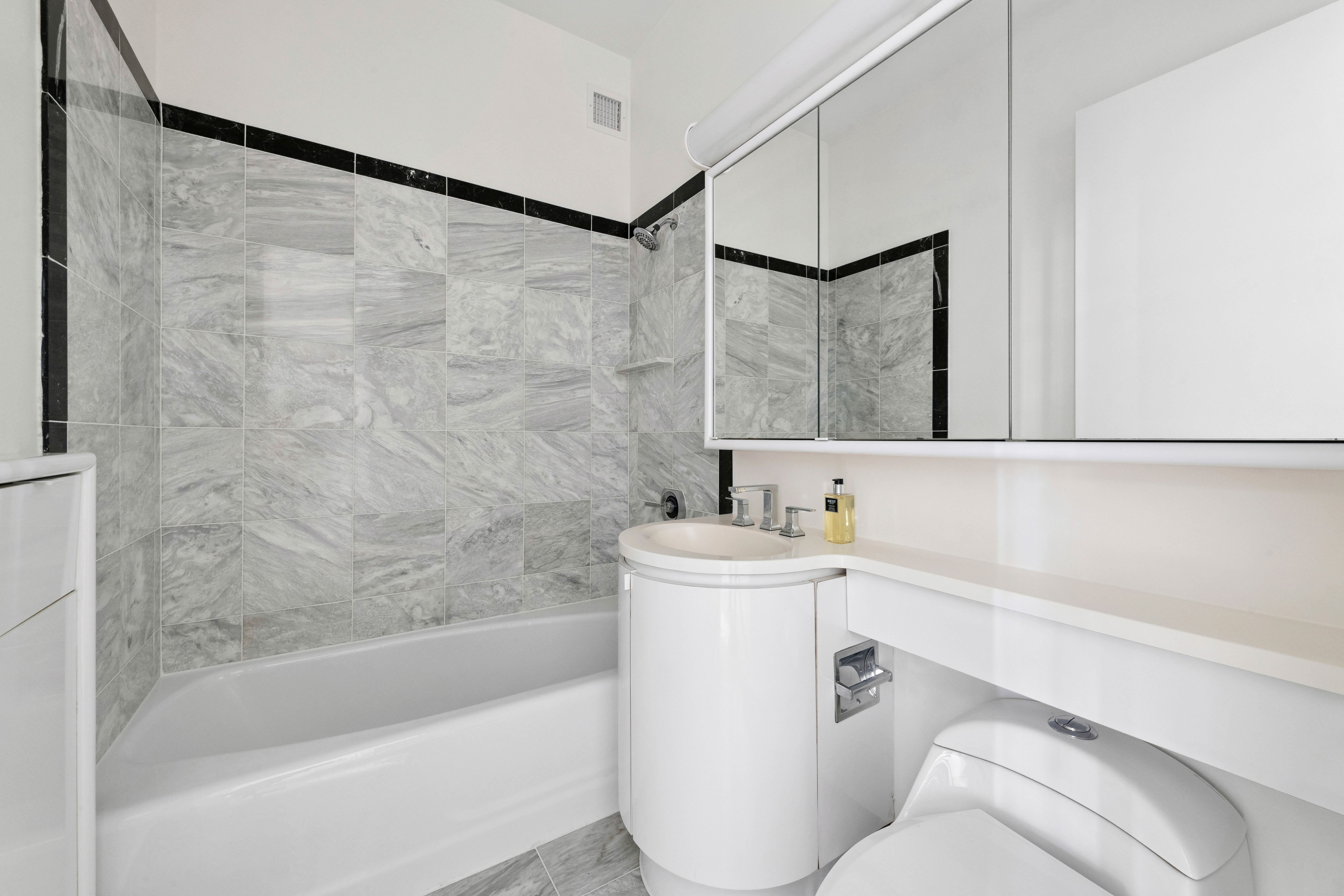 200 East 32nd Street, Unit 11D Manhattan, NY 10016 - Photo 13 of 19 a bathroom with a bathtub a sink a toilet and a mirror