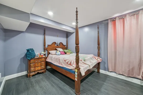 a bed sitting in a bedroom next to a window