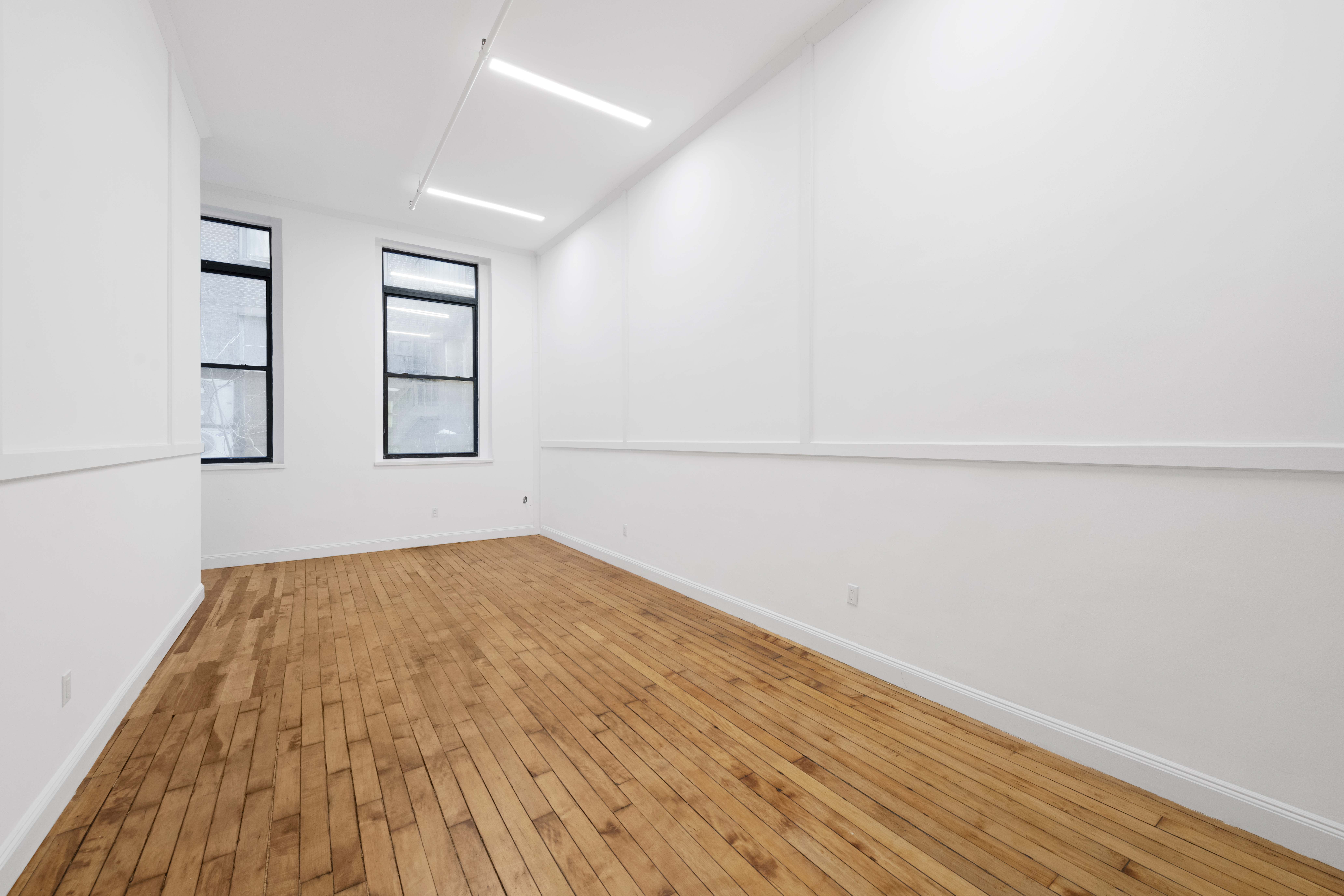 49 Walker Street, Unit 2B Manhattan, NY 10013 - Photo 3 of 7 a view of empty room with wooden floor and fan