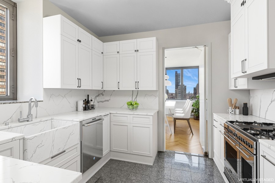 2 Columbus Avenue, Unit 23A Manhattan, NY 10019 - Photo 2 of 10 a kitchen with white cabinets and appliances