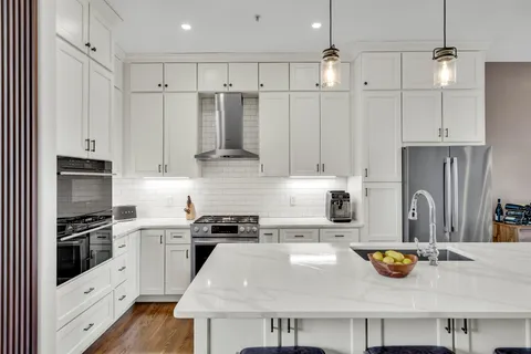 a kitchen with stainless steel appliances a stove a sink and a refrigerator
