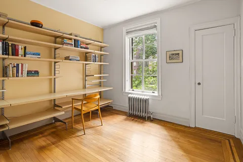 a living room with furniture a baby crib and a window