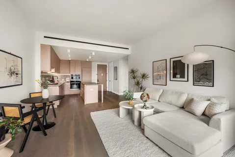 a living room with furniture and view of kitchen