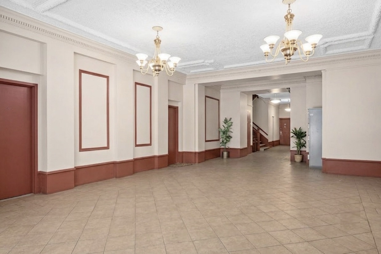 15 Fort Washington Avenue, Unit 4E Manhattan, NY 10032 - Photo 6 of 8 a view of a livingroom with a chandelier curtains and large windows