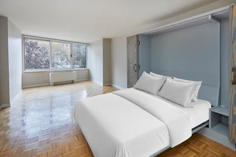 a spacious bedroom with a large bed and a large window