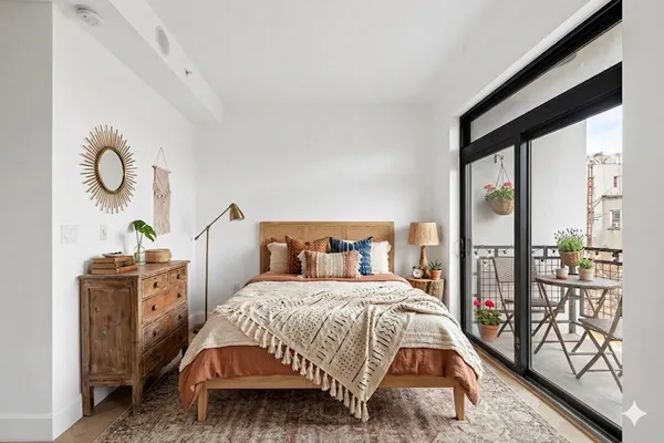 a bedroom with a bed and large windows