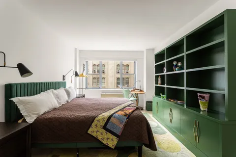 a bedroom with a bed a table and a large window